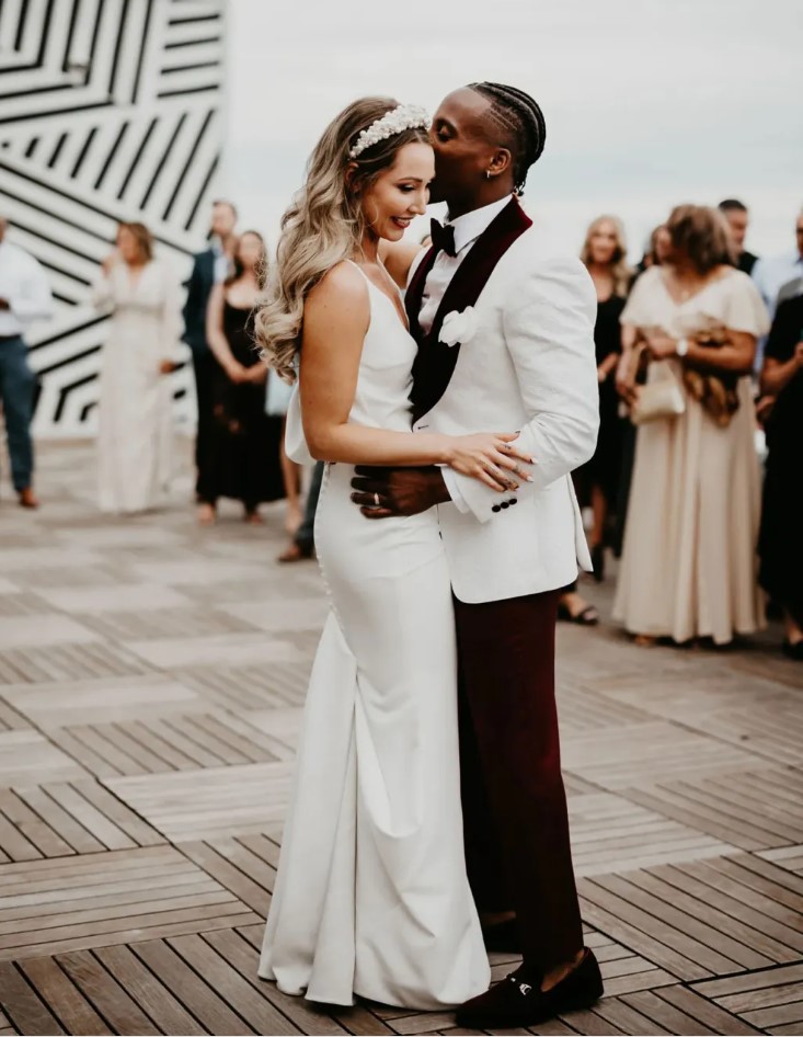 Couple dancing at a wedding reception to unique best first dance songs on the roof. Image Source: Brides