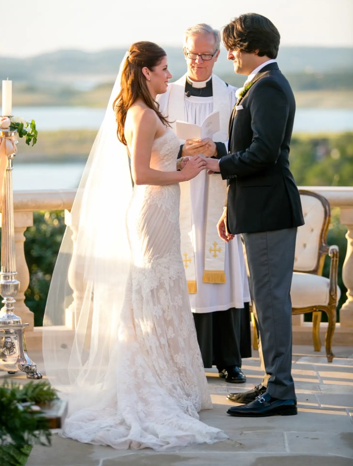 A priest blessing a white couple at their wedding. Image Source: TheKnot