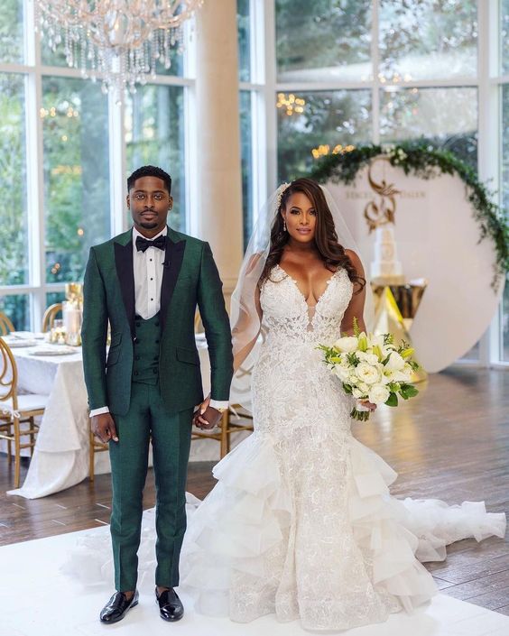 A groom in green suit with his bride. Image Source: dariuscordell.com