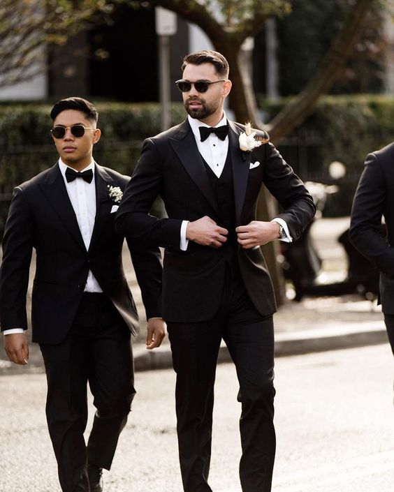 A groom in his black suit with a white shirt. Image: weddingforward.com