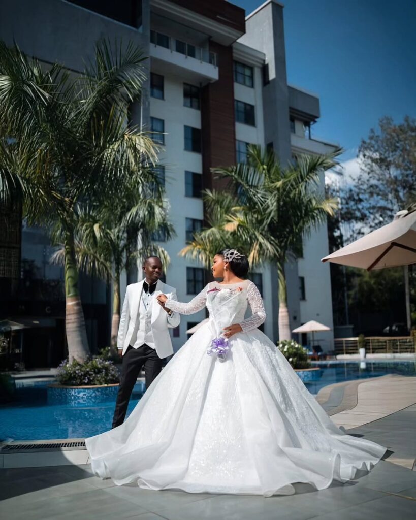 A beautiful couple pictured with the bride in her custom wedding dress from Whiterose Bridal. Image Source: Instagram/@whiterosebridal_ke